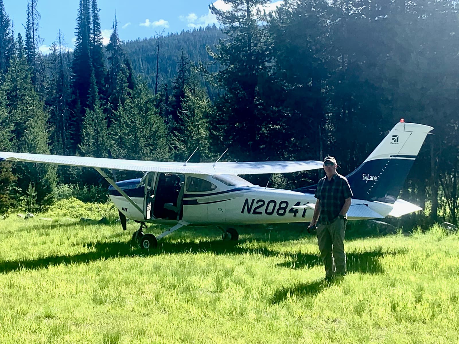 David standing next to his Cessna Skylane on a backcountry grass airstrip in Idaho
